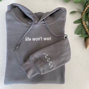 “Life won’t wait” embroidered sweatshirt